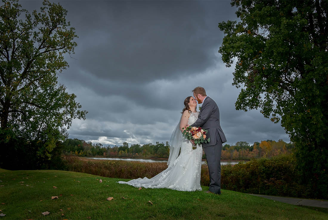The bride and groom try to get in some photos before the rainstorm hits at Beacon Hill Golf Club in Commerce Township,  Michigan.