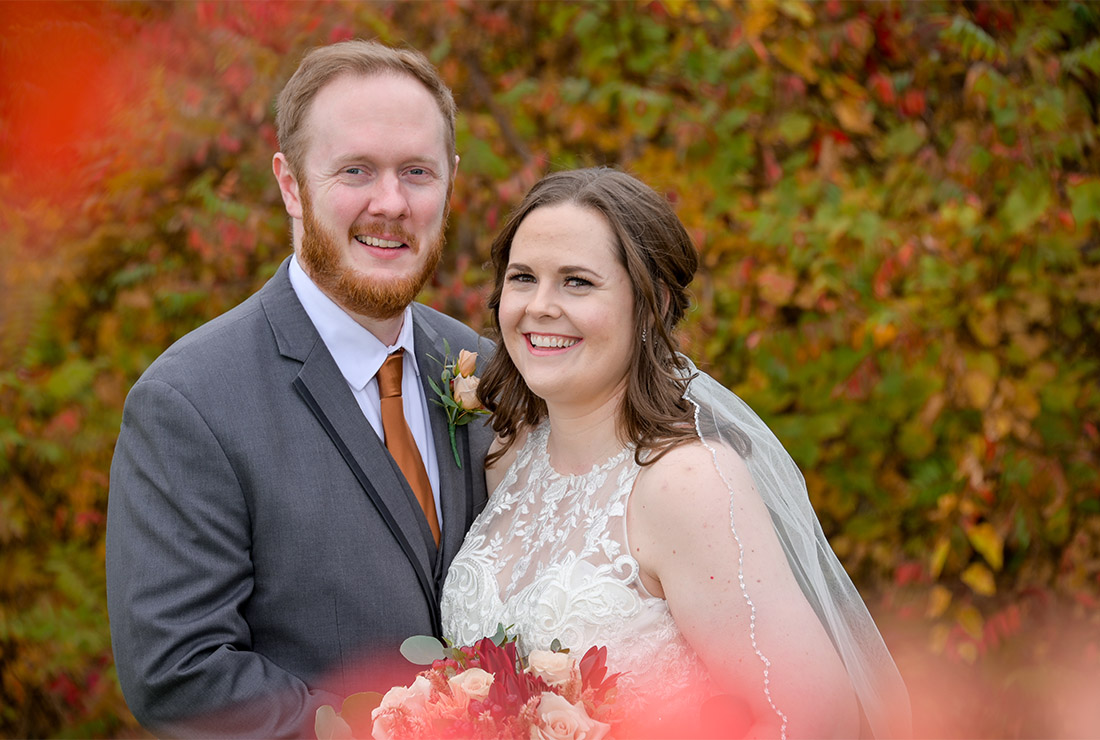 The bride and groom with a little bit of fall color left at Beacon Hill Golf Club in Commerce Township,  Michigan.