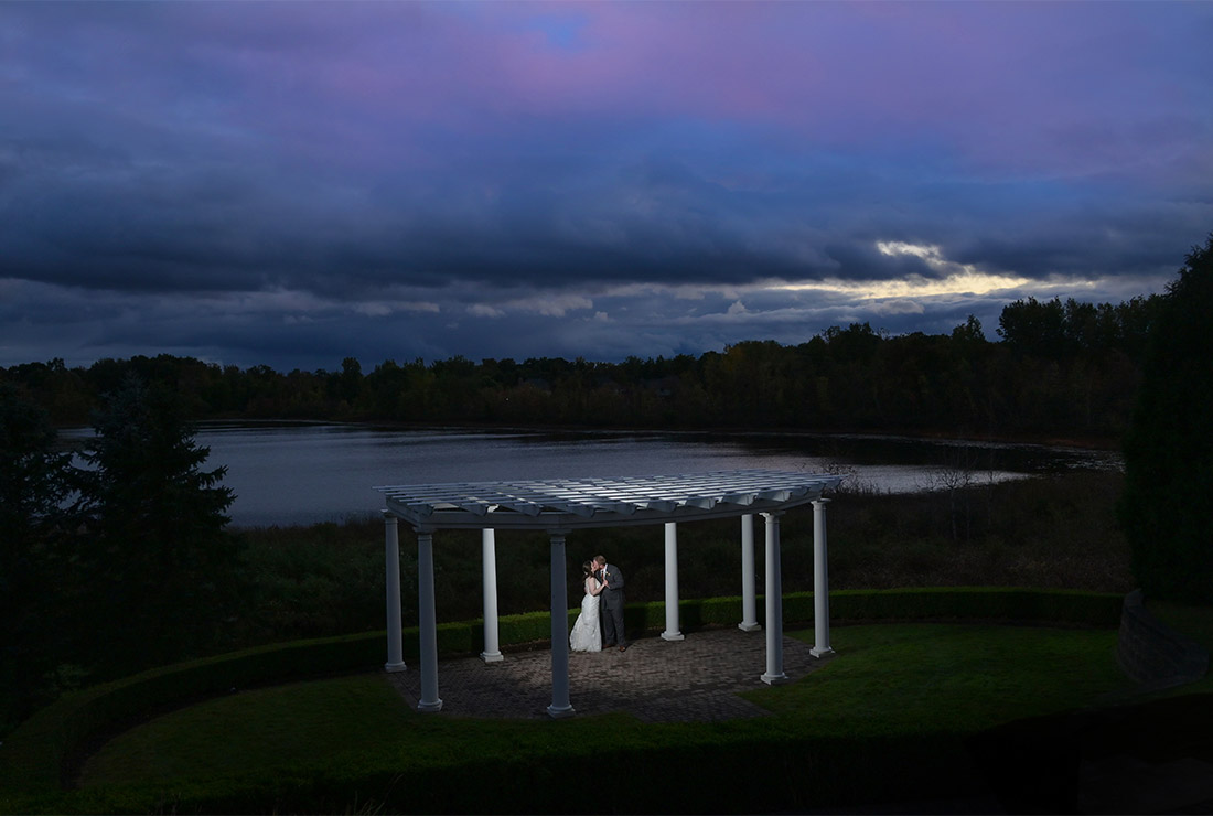The bride and groom cozy up outside after a rain storm delayed their wedding ceremony at Beacon Hill Golf Club in Commerce Township,  Michigan.