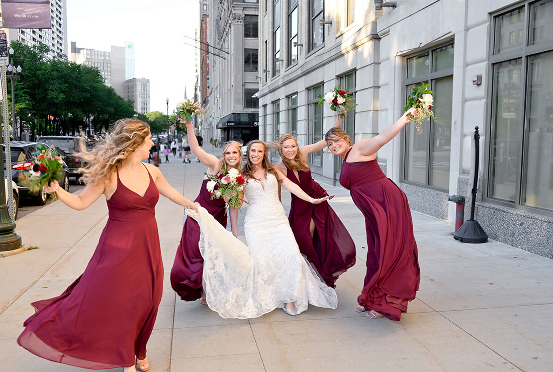 The bridemaids blowing in the wind outside their reception venue in Detroit, Michigan.
