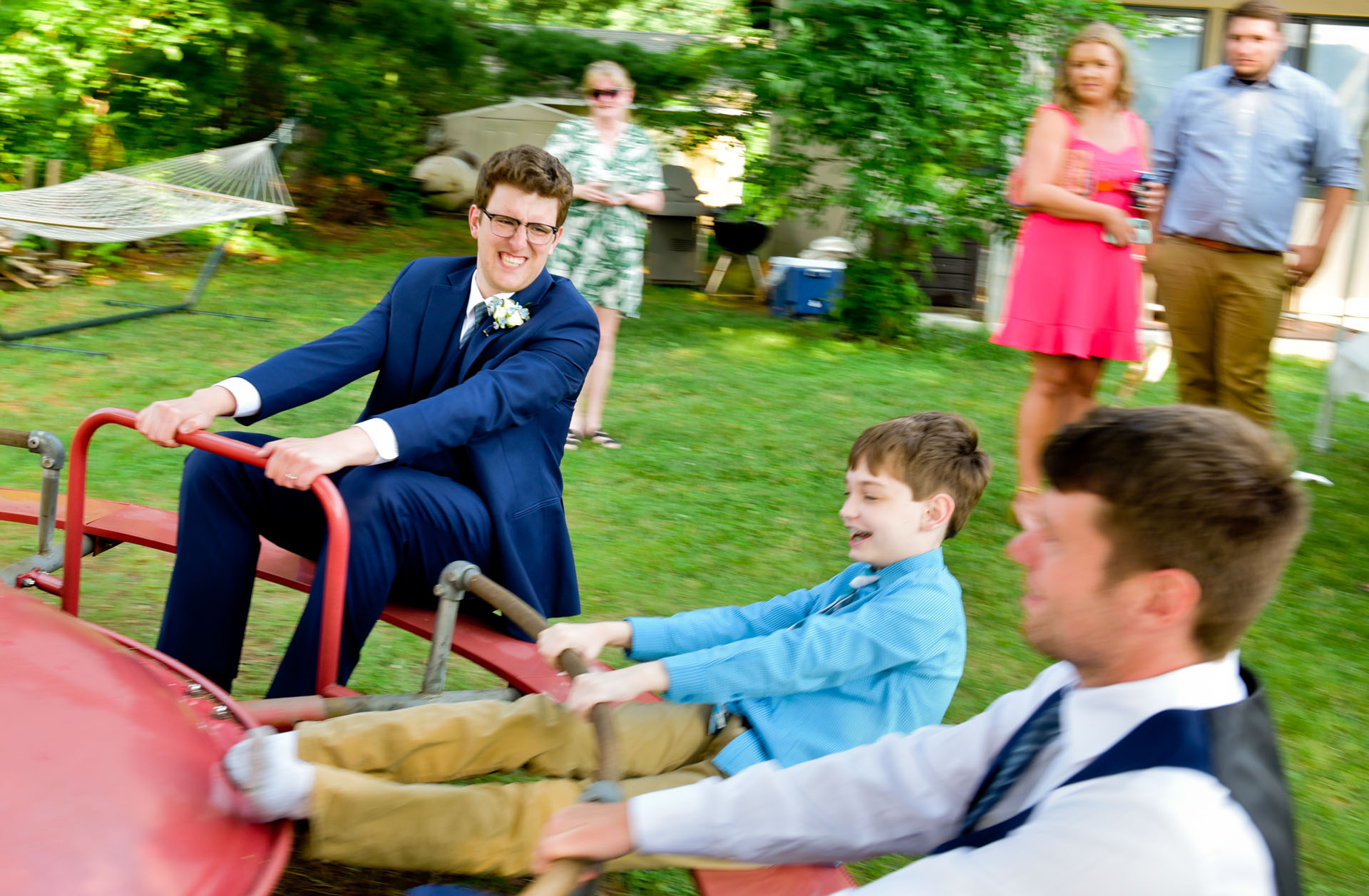 A groom in Brighton, Michigan jumps on a piece of playground equipment for this hilarious and playful wedding photo.