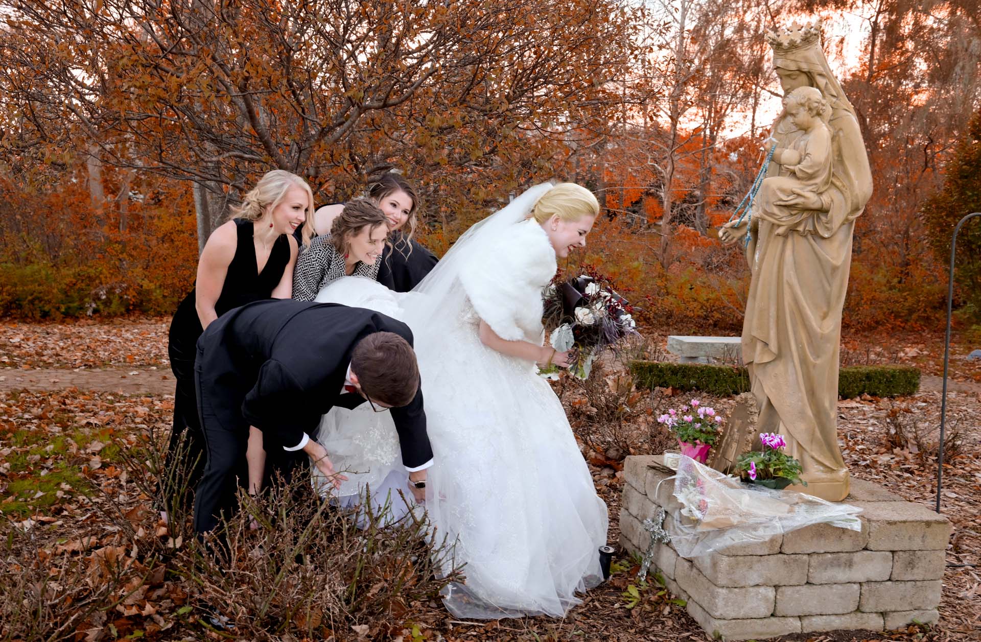 The bride tries to place her offering of flowers to St. Therese as a blessing, but snagged on the rosebushes at the altar at the St. Therese of Lisieux Catholic Church in Shelby Twp., Michigan.
