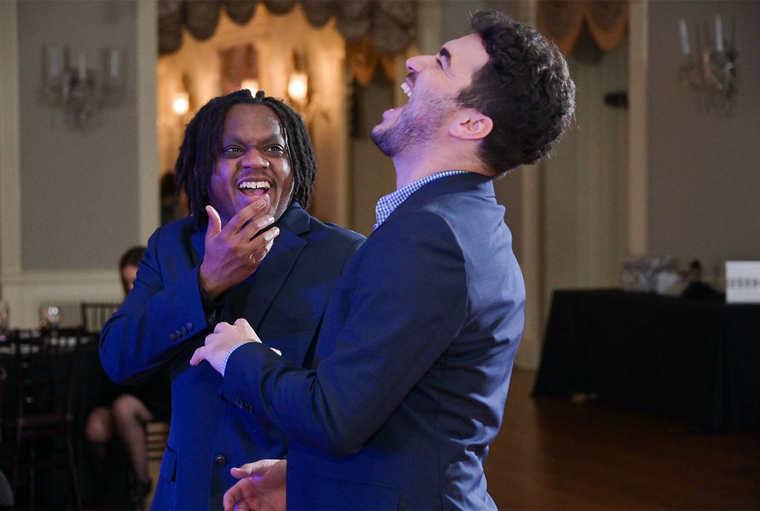 Guests laughing during the wedding reception at Lovett Hall at the Henry Ford Museum in Detroit, Michigan.
