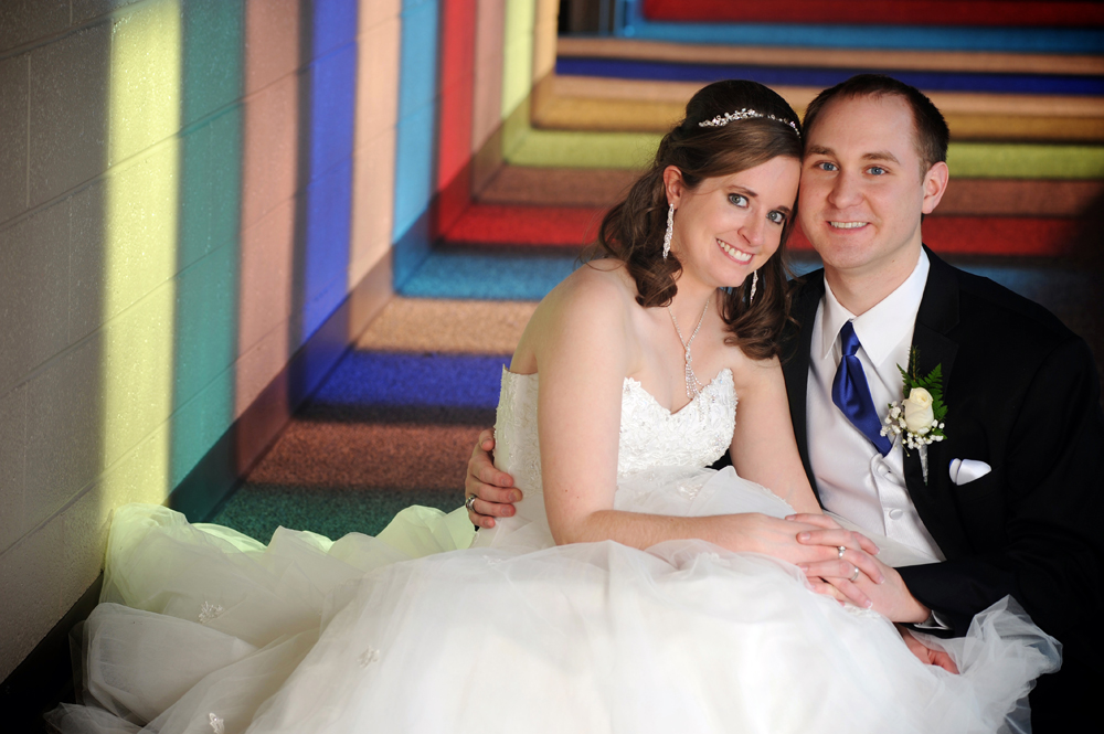 A couple lay happily in their church's corridor after their Macomb, Michigan wedding.
