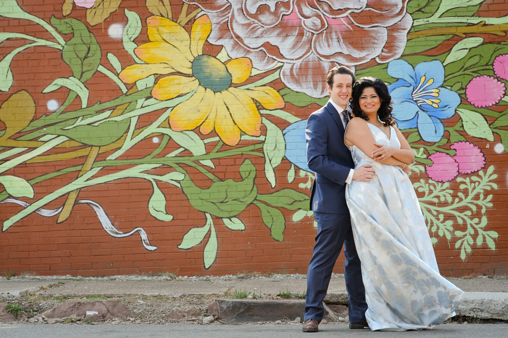 A Detroit wedding couple poses at Easter Market downtown Detroit, Michigan before their Masonic Temple wedding reception begins.