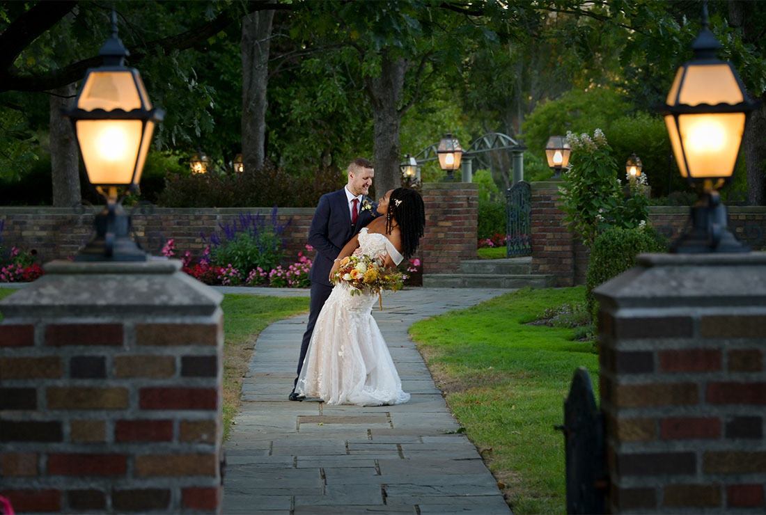 The bride and groom in the gardens at sunset at Meadowbrook Hall in Rochester, Michigan.