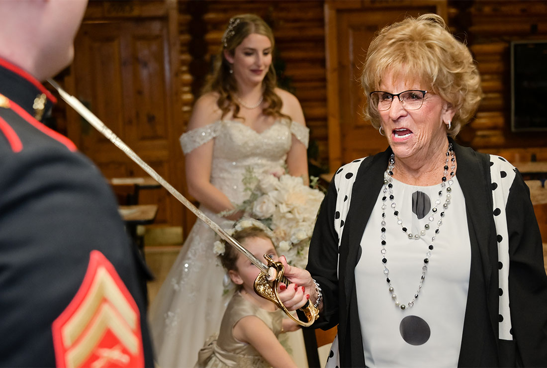 The bride's grandmother threatens the groom with his sword during their wedding reception in Clarkston, Michigan.