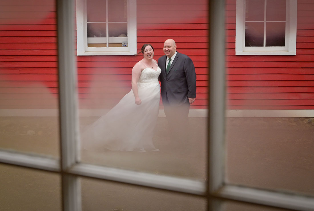 The bride and groom seen through frosted glass after their chilly wedding at Mills Race Historical Village in Northville, Michigan.