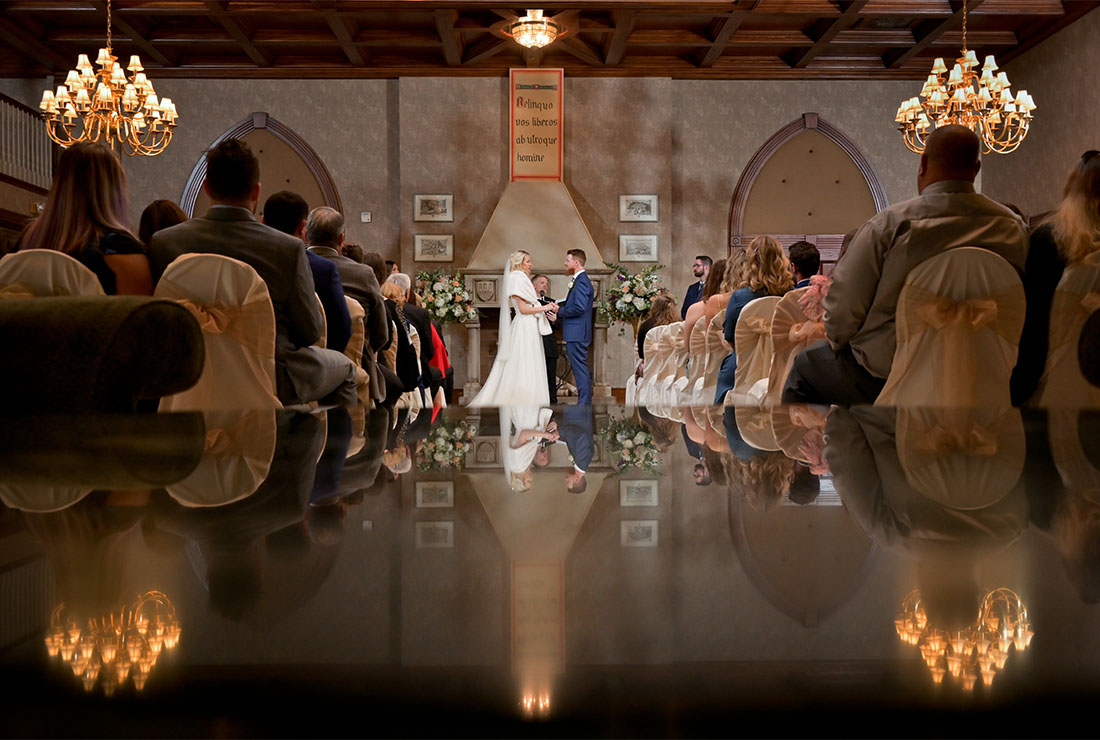The bride and groom are reflected in marble during their wedding ceremony at the San Marino Club in Troy, Michigan.