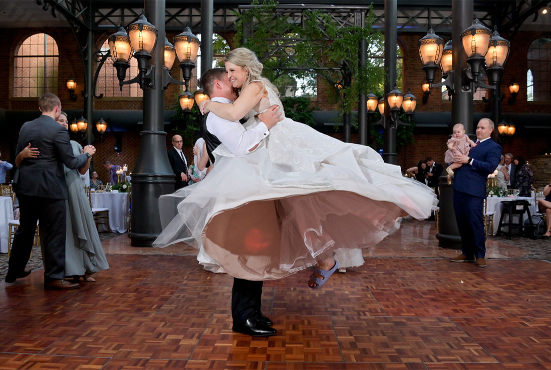 The bride leaps into the grooms arms during a slow dance at St. Johns Resort in Plymouth, Michigan