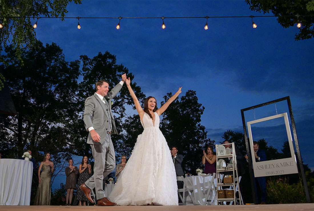 The bride and groom take the dance floor at dusk outdoors for their first dance  at Strawberry Lake Lodge in Pinkney, Michigan.