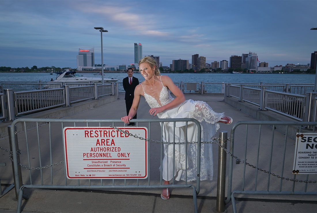 The bride jumps a barrier on the docks after her wedding at the Waterview Loft in Detroit,  Michigan.