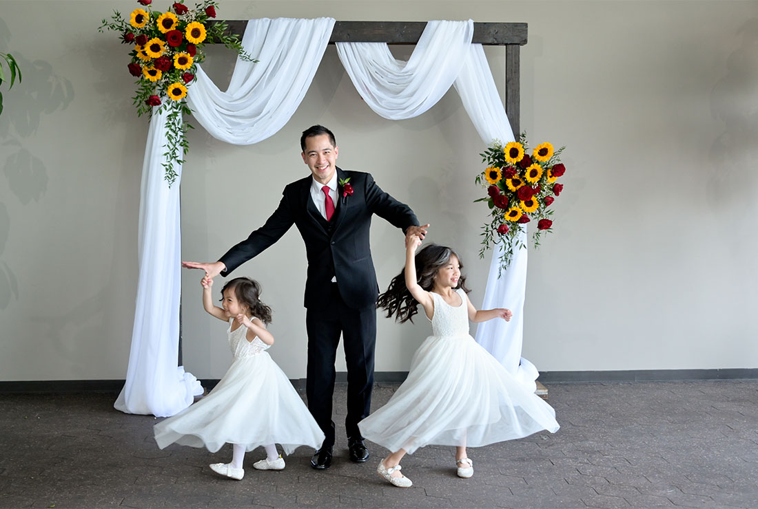 The groom twirls his daughters before his wedding at the Waterview Loft in Detroit,  Michigan.