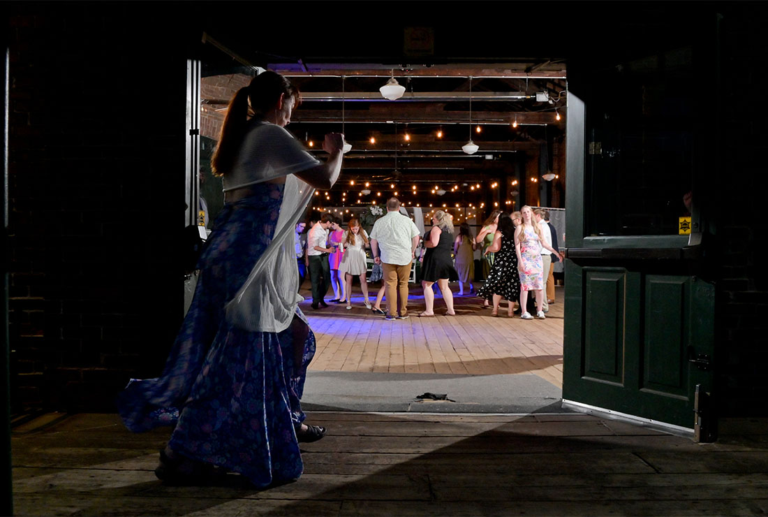 A guest runs in to join the dancing for the wedding at the Freighthouse in Ypsilanti, Michigan.