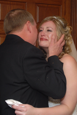The bride cries as her father kisses her after her wedding ceremony in Troy, Mi