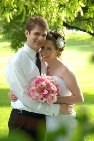 The bride and groom pose after their outdoor ceremony in White Lake, MI