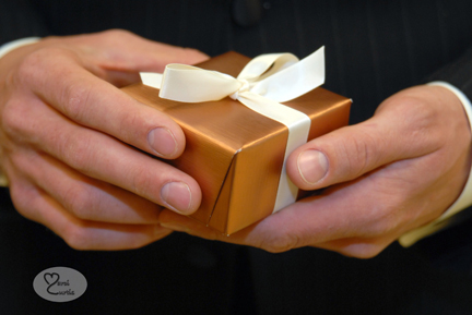 Groom holds a box with a gift for his bride