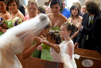 The bride kisses the flowergirl during the ceremony