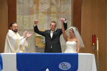 The bride and groom raise their arms during the wedding ceremony in chelsea, Michigan