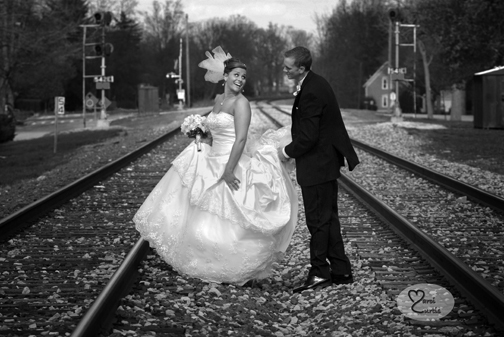 The groom helps the bride across the railway tracks in Chelsea Michigan