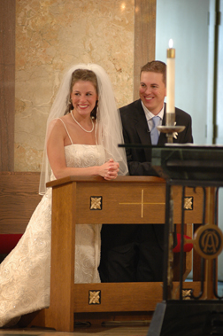 The bride and groom watch their guests during their Michigan catholic wedding.