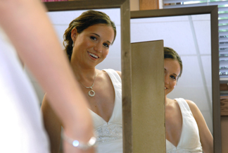 MSU bride checks herself out in two mirrors before her Lansing wedding in Michigan.