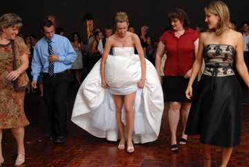 Bride teaches a new dance to wedding guests by hiking up her dress so they can follow along during Macomb County wedding.
