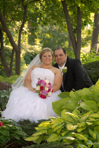 Wedding couple pose for photos at a park in Macomb, MI