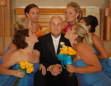 Groom's not too sure he wants to be kissed by beautiful bridesmaids at a wedding shot by michigan wedding photographer