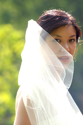 The bride tries to fight with her veil during photos at the Cobblestone Farm in Ann Arbor Michigan