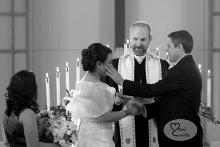 Groom wipes a tear from his bride's cheek during ceremony