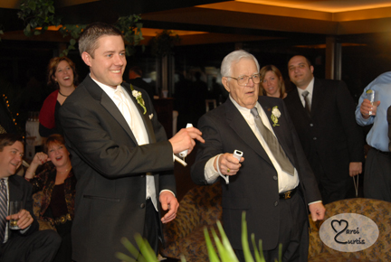 The groom plays Wii with his grandfather during the wedding reception