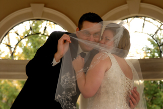 The groom plays peek a boo with the bride's veil in michigan