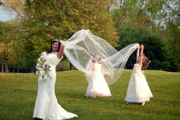 Bride gets her veil fluffed by bridesmaid during Black River Country Club MI wedding