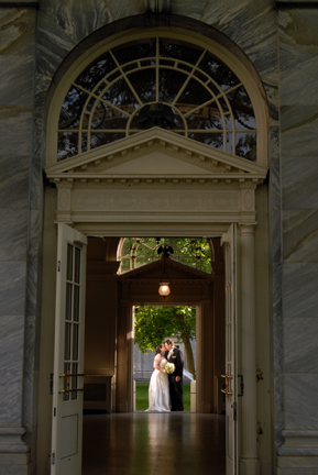 The Bride and kiss in the archway of their Henry Ford Museum wedding in Dearborn, MI