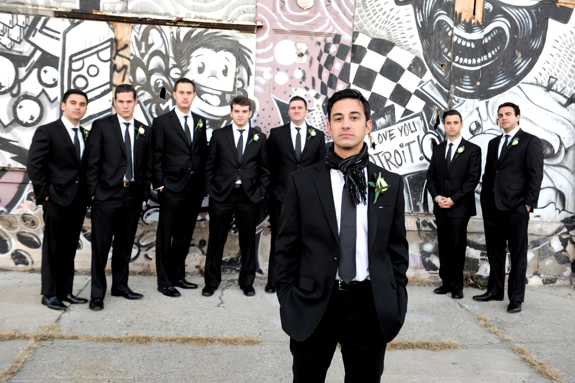 The Historic church Sweetest Heart of Mary and the Dearborn Inn of Detroit's historic church in Detroit and Dearborn, Michigan wedding photographer's  photo of the groom and his groomsmen near the Detroit's historic train station for wedding photos in Detroit, Michigan with local graffiti art.