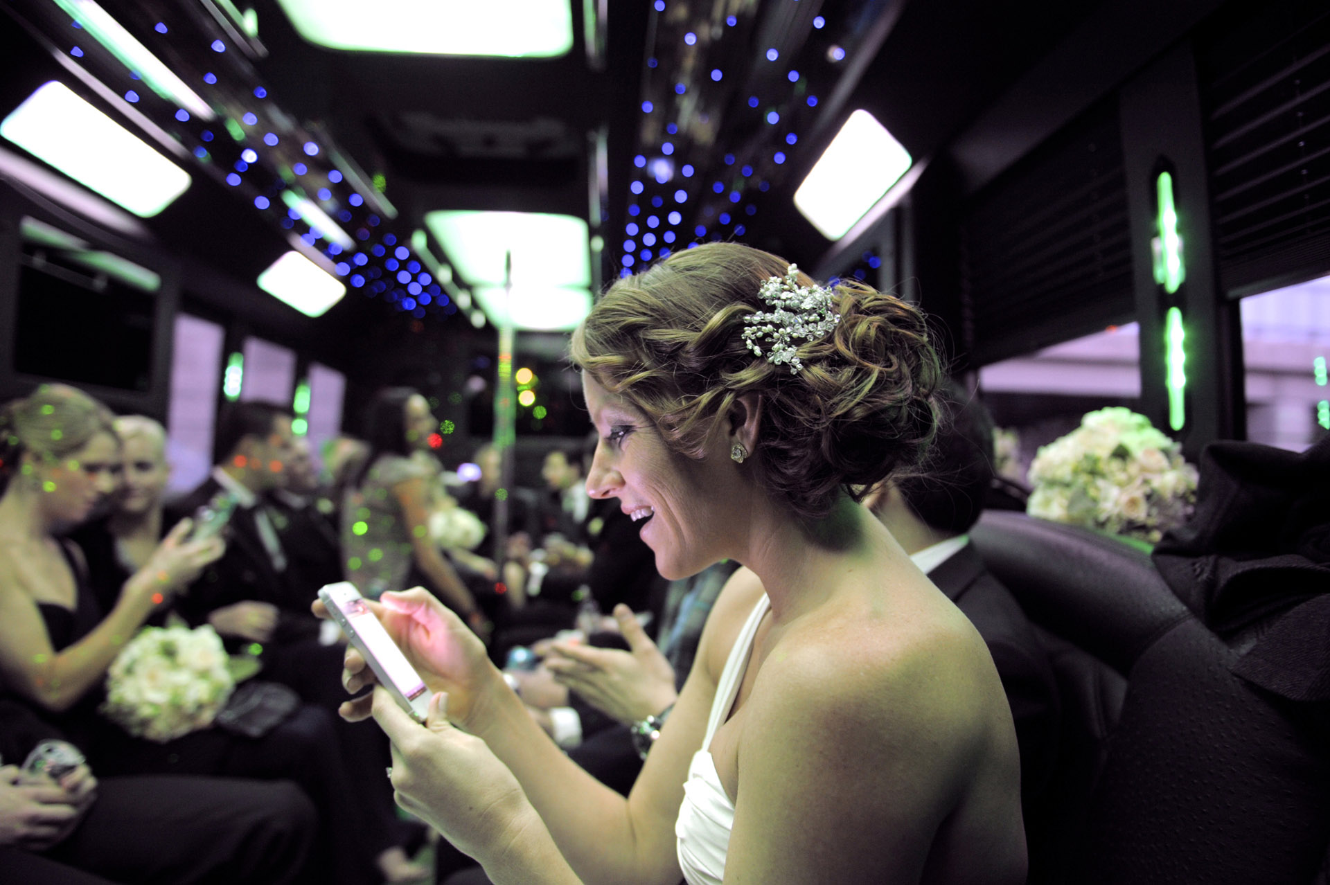 The Historic church Sweetest Heart of Mary and the Dearborn Inn of Detroit's historic church in Detroit and Dearborn, Michigan wedding photographer's of the bride changing her Facebook status in the limo bus on her way to her wedding reception at the Dearborn Inn in Dearborn, Michigan.