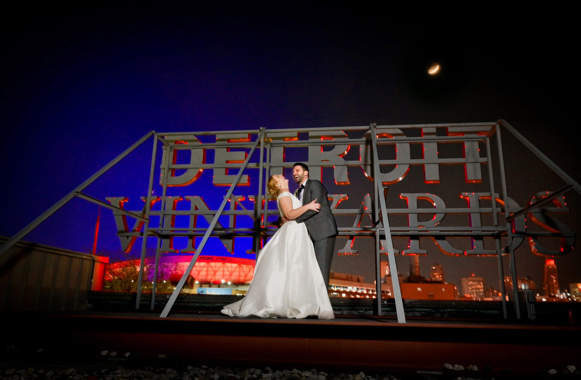Wedding couple at twilight during a winter wedding on the rooftop of the Whiskey Factory downtown Detroit, Michigan.
