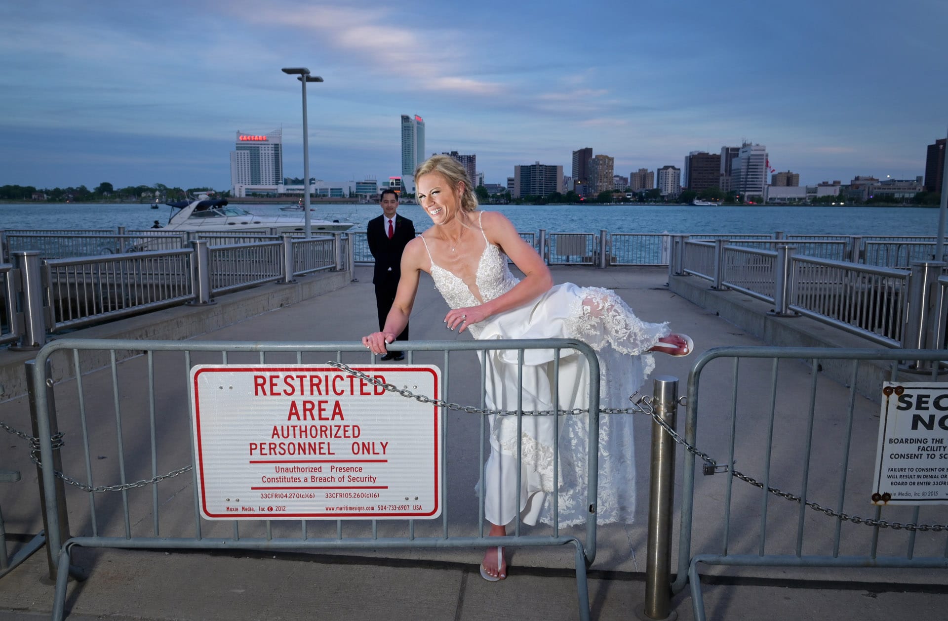 A bride heads back over a barricade in front of their wedding venue, The Waterview Loft downtown Detroit, Michigan. Yes, we did have permission from the police to be there.