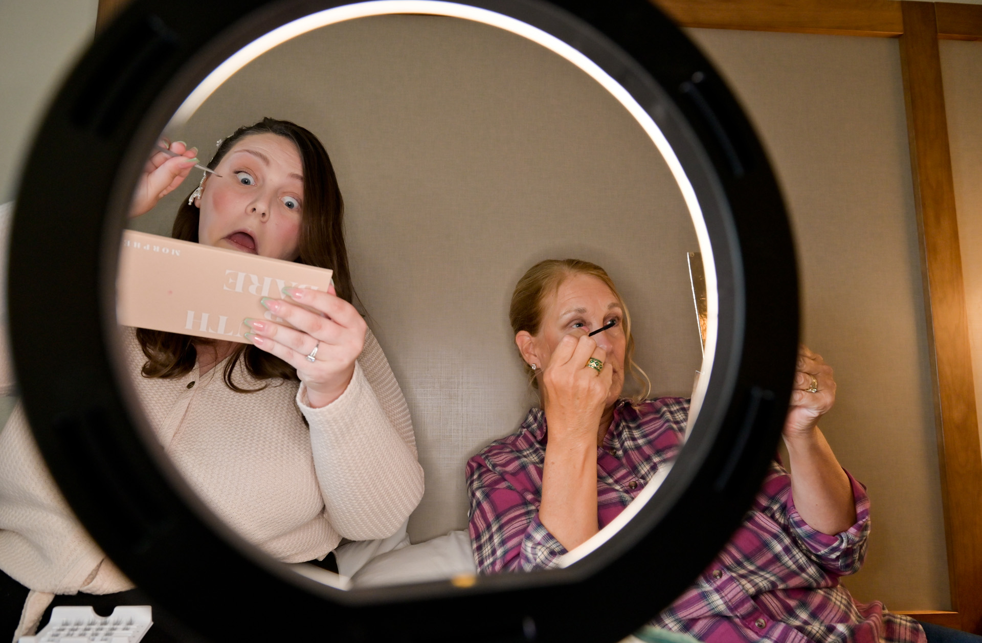 The bride and her mother get ready together applying their makeup  at the hotel before the bride's wedding in Grand Blanc, Michigan.