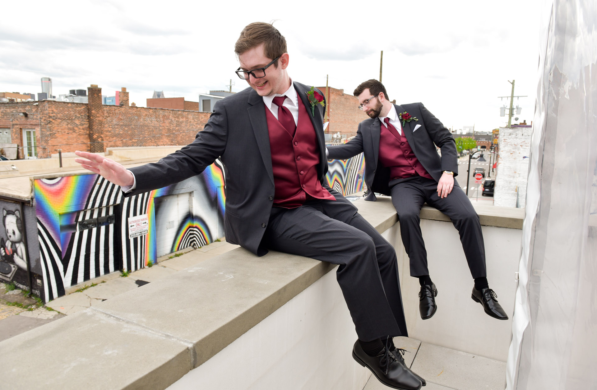 Groomsmen wave to arriving wedding guests from on top of 