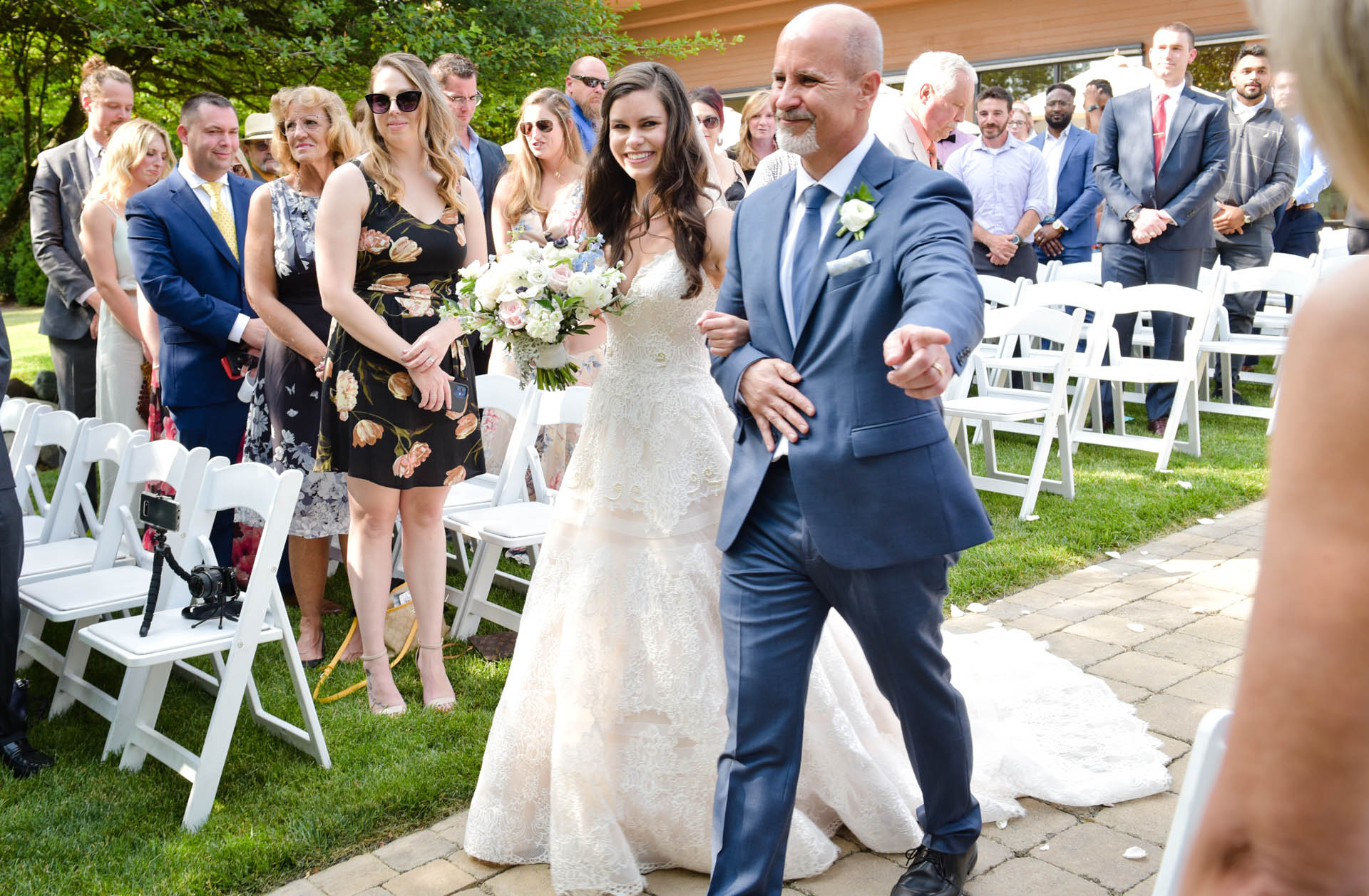 The father of the bride points at the bride's mom to stop her from crying (and setting him off) during this Stonebridge Golf Course wedding in Ann Arbor, Michigan.
