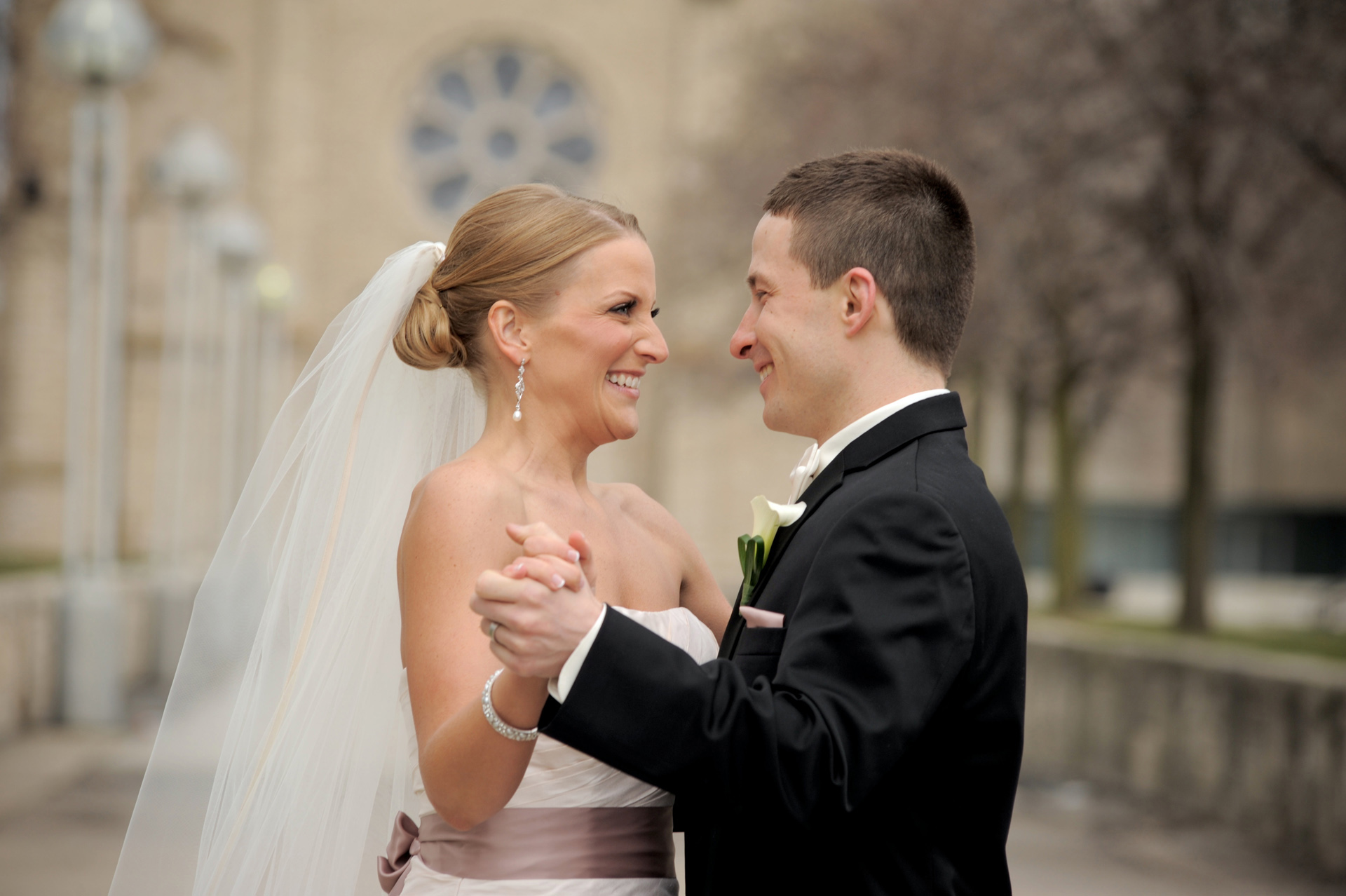 A windy winter wedding in Michigan photographer's photo of the wedding couple dancing in Detroit, Michigan, Michigan wedding venue St. Aloysius Detroit, Michigan and the Detroit Athletic Club.