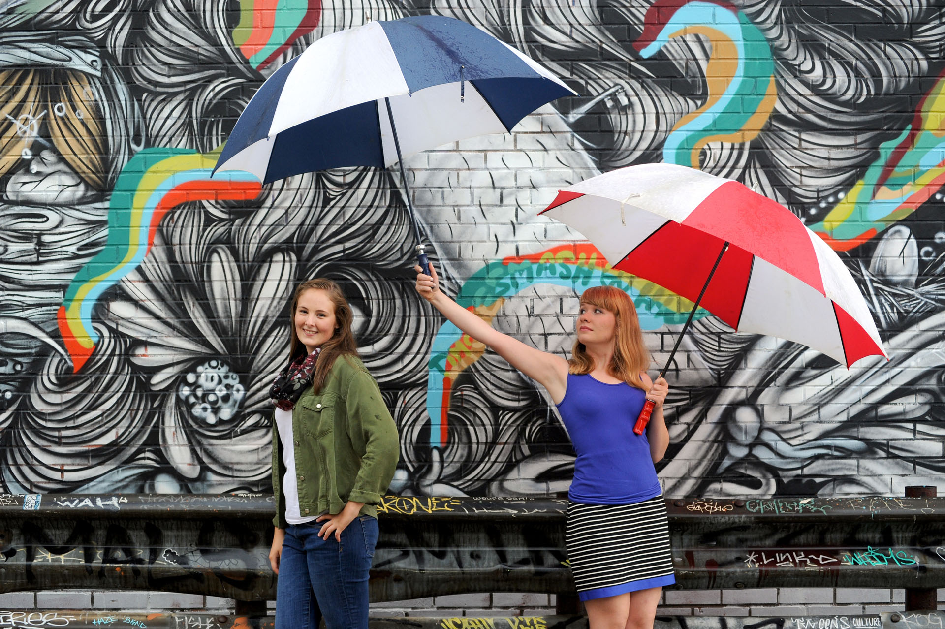 Best Detroit senior photographer's high school senior picture of two seniors helping each other during a rainy senior photo shoot  in downtown Detroit, Michigan.