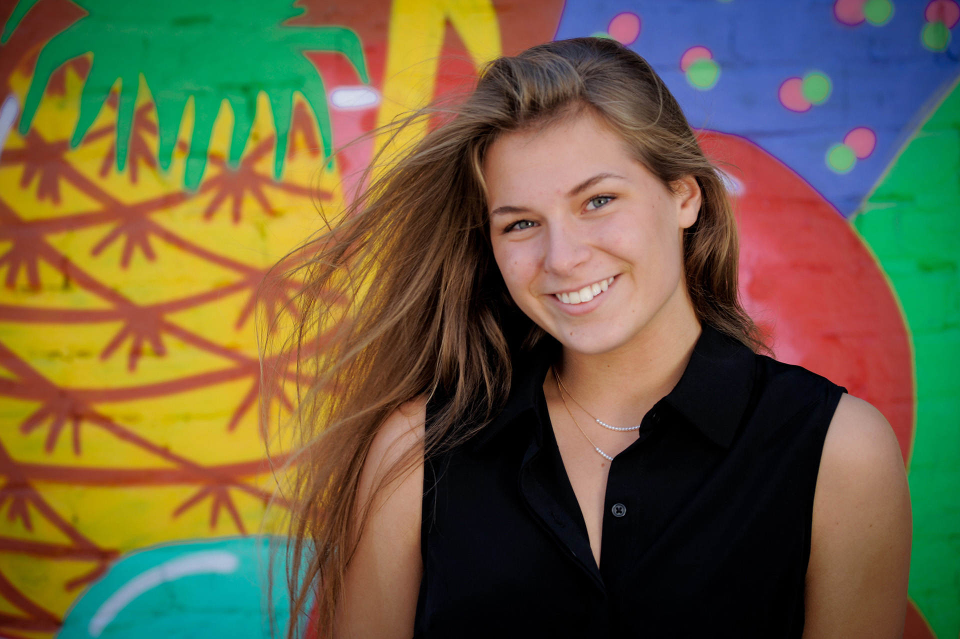 Best Detroit senior photographer's high school senior picture of a senior with bright graffiti art from downtown Detroit, Michigan.