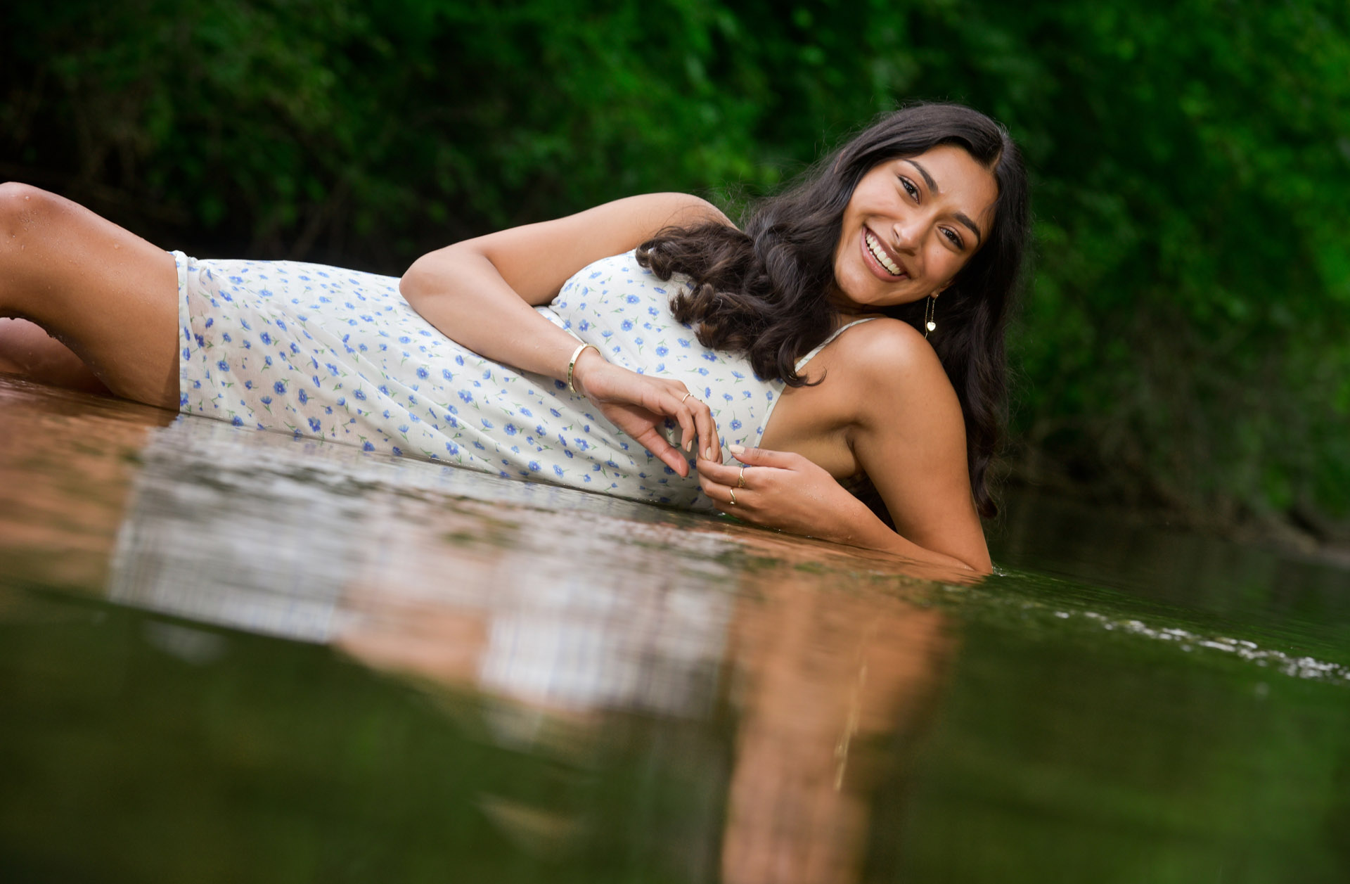 Rochester high school senior poses in a river in Rochester, Michigan for this lovely, unique senior picture.