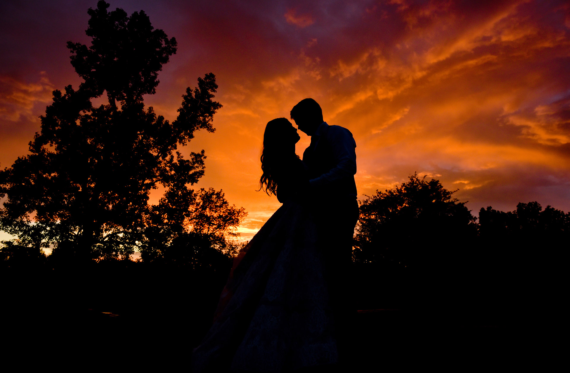 Bride and groom on top of a hill after a storm made this dramatic sunset photo at Stonebridge Golf Course in Ann Arbor, Michigan.