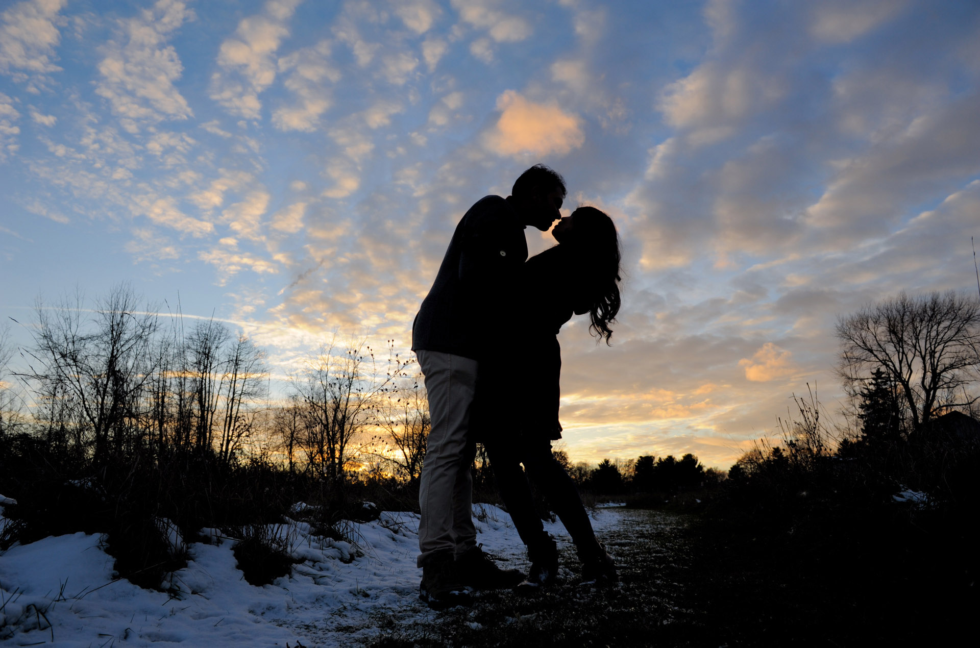 Best Troy lifestyles photographer takes a photo of a engaged couple snuggling at sunset at a park in Metro Detroit and Troy, Michigan.