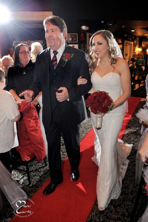 Michigan winter bride is escorted down the aisle at Steven Lelli's restaurant in Farmington Hills, Michigan.
