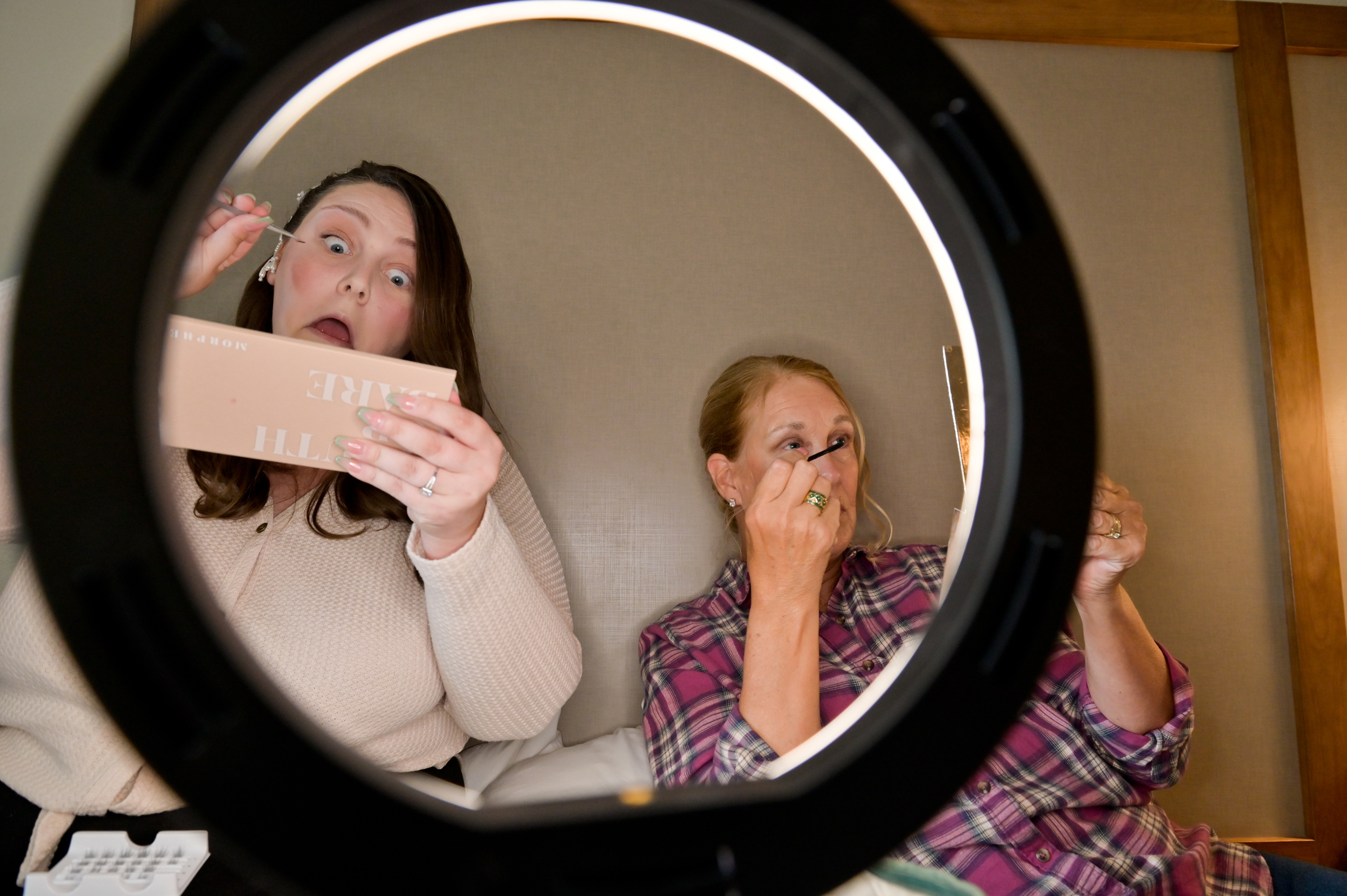 Mother and daughter share a ring light while they get ready together for the wedding in Grand Blanc, Michigan.